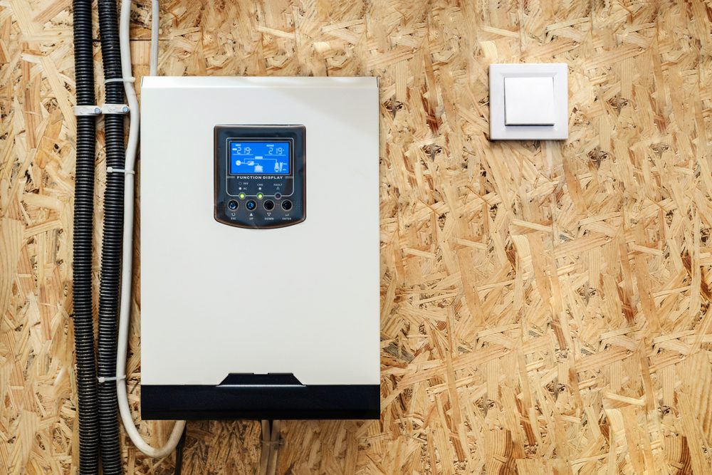 Wall-mounted hybrid inverter with its LCD settings display lit up